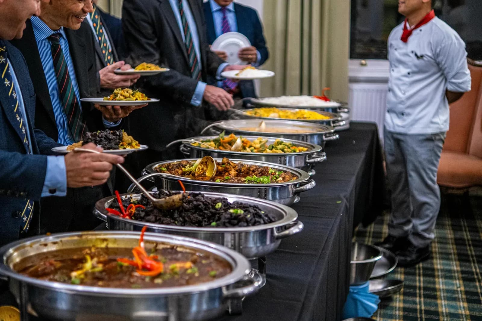 Guests in suits serving themselves from a corporate lunch buffet