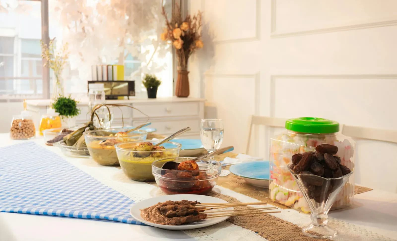 Small spread of bowls, skewers and snacks laid along a table runner