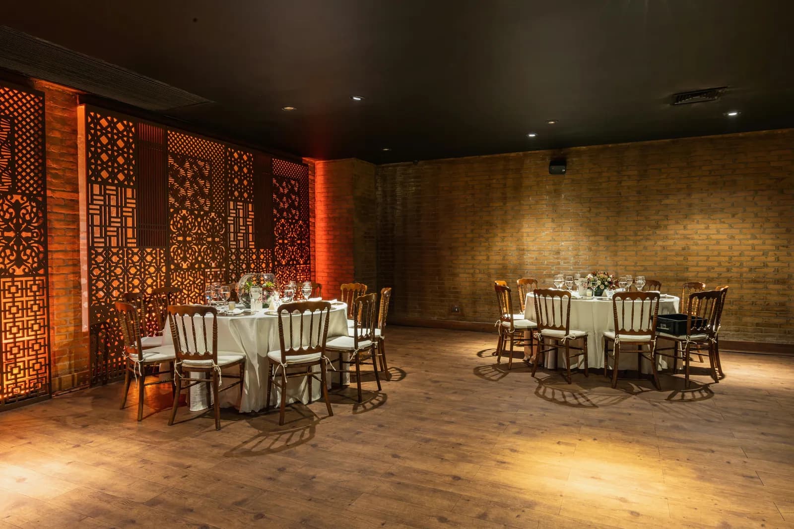 Banquet hall with carved wooden lattice walls and round dining tables