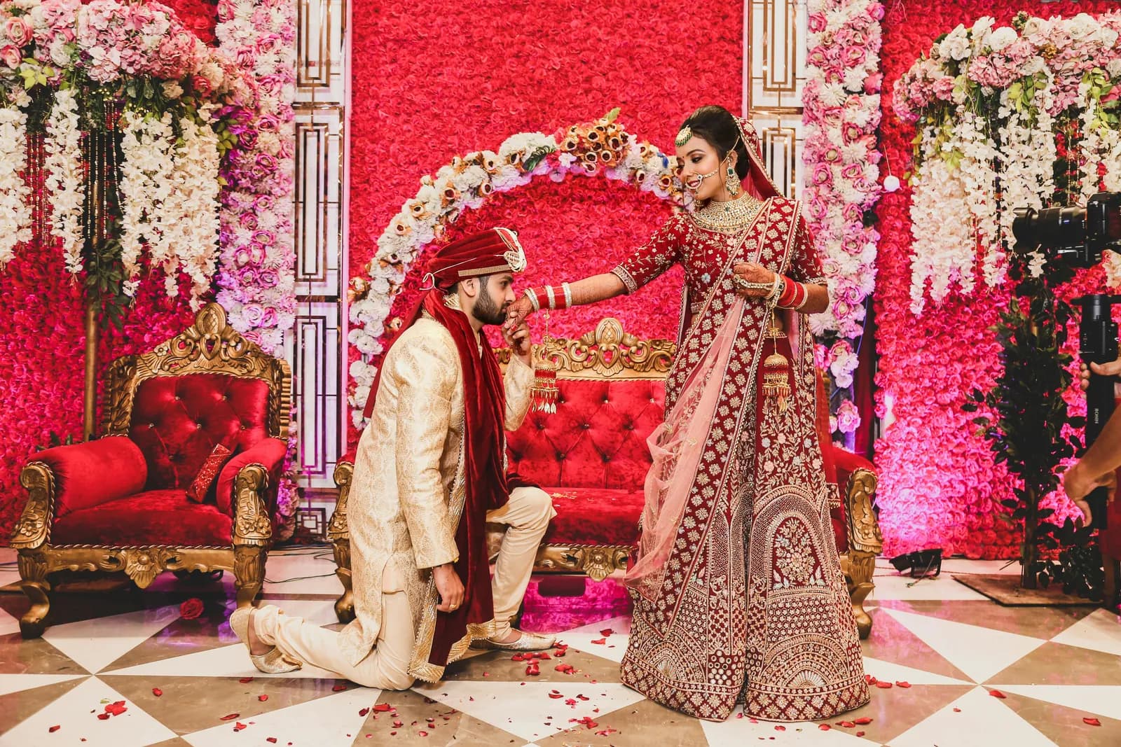 Bride and groom on a red floral wedding stage