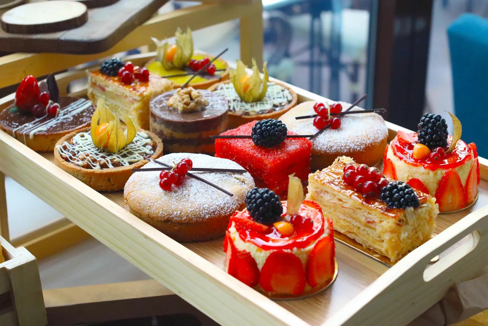 Tray of tarts, pastries and berry-topped cakes at a dessert station