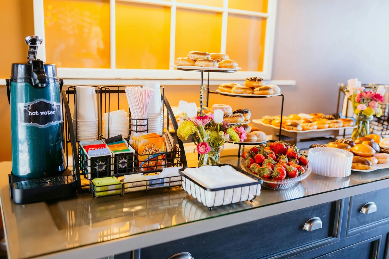 Refreshment counter with a hot-water urn, doughnuts, pastries and strawberries