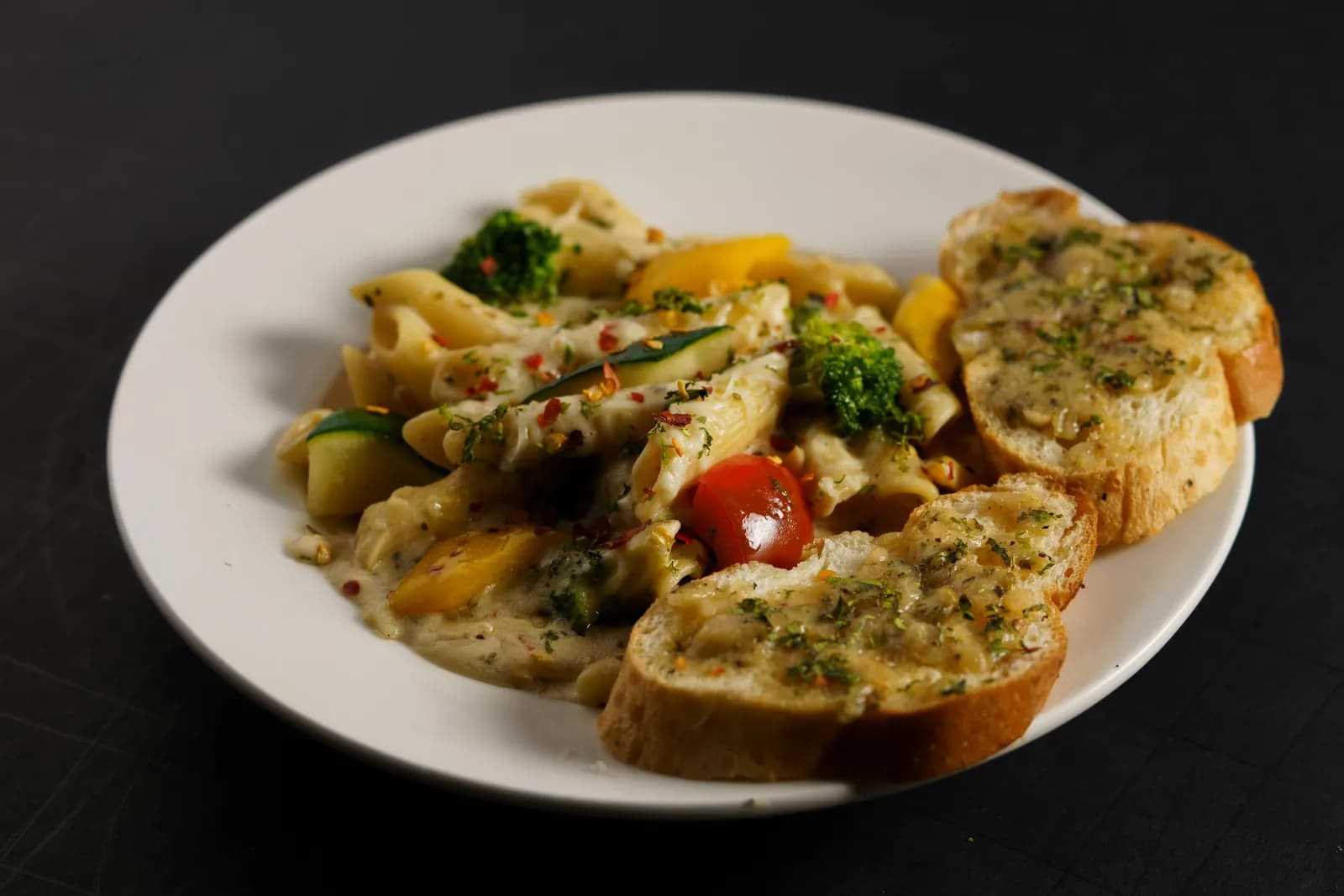 Plate of penne pasta with garlic bread from the live pasta station